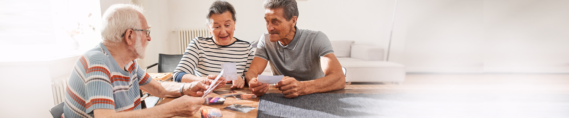 Two men and one woman sitting at table looking at paperwork